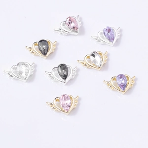Detail of alloy heart nail charms with angel wings and colorful pear-cut crystals