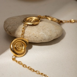 18k gold-plated stainless steel necklace with spiral snail shell pendants on stone surface