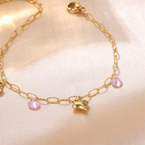 18K gold plated bracelet with heart pendant and pink crystal on silk background