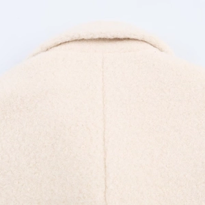 Detailed close-up showing the pebbled wool texture and precise collar stitching of the coat