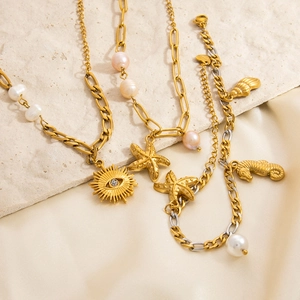 Detail of 18K gold stainless steel bracelet featuring pearls, starfish and eye charms