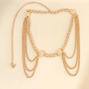 Elegant multi-layered gold chain waist belt with circular metal buckles on beige background
