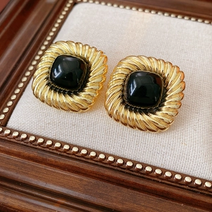 Detailansicht der Vintage Gold-Ohrringe mit schwarzem Edelstein und gedrehter Seilstruktur