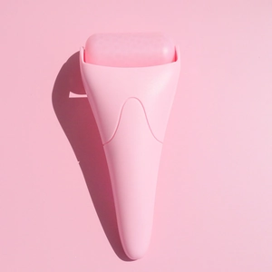 Close-up of a pink ice roller with gel head for cooling face massage and skin care