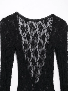 Close-up view of intricate black lace fabric with backless design and long sleeves