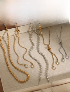 Macro detail of PVD plated stainless steel jewelry set with zircon beads and pull chains