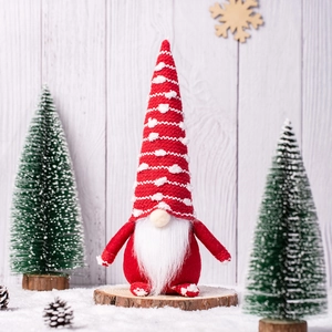 Red Christmas gnome plush doll with white beard on wooden base with pine cones decor