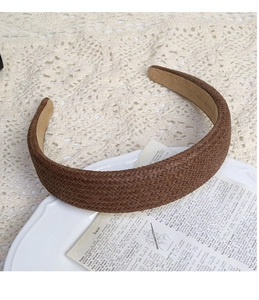 Close-up of brown woven cotton linen headband on a white ceramic tray with lace