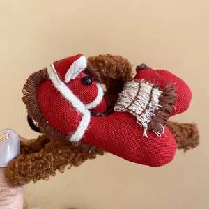 Close-up of a red plush pony hair claw clip with soft fabric and woven details
