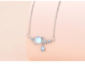 Close-up of planet pendant necklace with moonstone and sparkling teardrop zircon accents