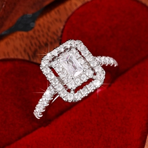 Macro-opname van ring met rechthoekige steen, dubbele halo en pavé-zetting op pluche