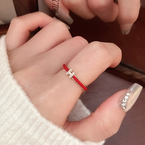 Close-up of red enamel gold snake ring with a zircon-paved H letter charm detail