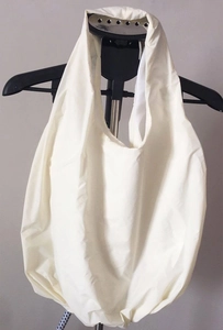Close-up of white pleated nylon shoulder bag with soft fabric texture and wide handle