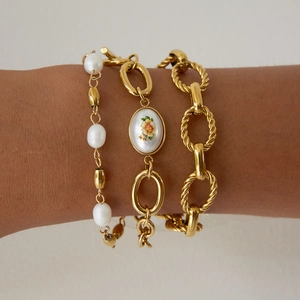 Ensemble de bracelets dorés superposés avec perles d'eau douce et breloques florales