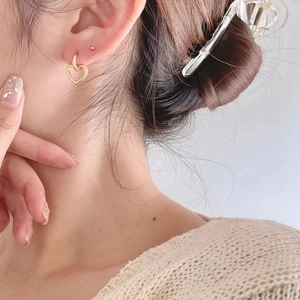 Minimalist gold heart-shaped hoop earring worn by a model for a chic daily style