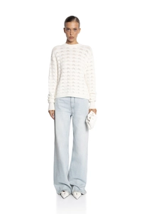 Close-up of white hollow-out knit sweater showing delicate texture and craftsmanship