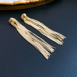 Elegant gold knot tassel earrings with sleek snake chain fringes on black background
