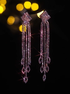 Macro shot of luxury rose pink long tassel earrings with sparkling rhinestone detail