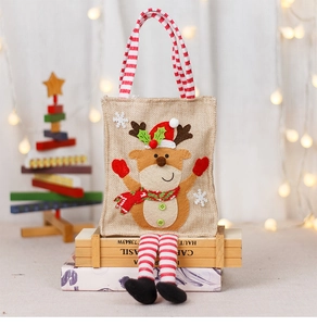 Close-up of burlap Christmas gift bag with reindeer applique and striped handles