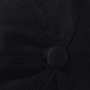 Close-up of the black cotton twill squatchee button showing premium fabric texture