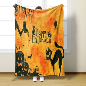 Detail of Halloween flannel blanket featuring pumpkin, bat and cat prints with Happy Halloween text