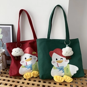 Detail of canvas tote bags in burgundy and dark green with cute duck print and cloud charm
