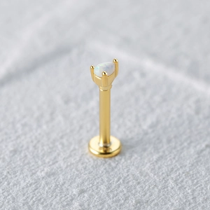 Macro detail of S925 sterling silver ear stud with pear-shaped white opal on white stone