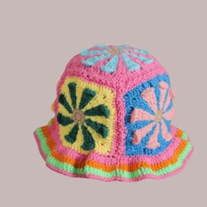 Detailaufnahme der handgefertigten Häkelmuster und bunten Stickereien auf der Strickmütze