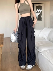 Detail view of black high-waist cargo pants with side pockets and a wide-leg straight cut