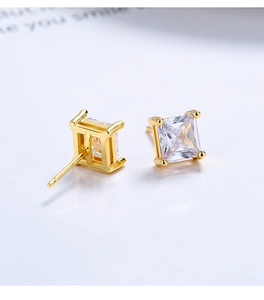 Détail des boucles d'oreilles en zircon carré avec sertissage à quatre griffes dorées
