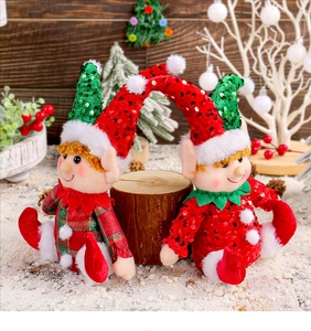 Close-up of Christmas elf dolls with sequined hats sitting in a festive winter snow scene