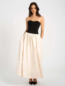 Détail d'une robe bustier élégante avec corsage noir et jupe ivoire fluide et longue