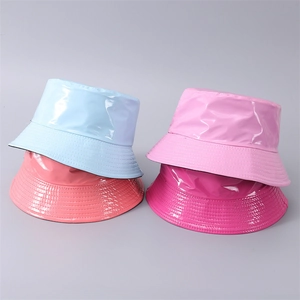 Dettaglio di cappelli a secchiello in pelle PU lucida in colori vivaci con cuciture