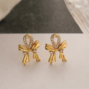 Macro shot of 18K gold plated bow earrings with sparkling crystal pavé details