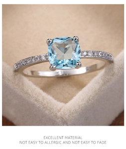 Macro view of square blue zircon ring with sparkling side diamonds in a silver setting