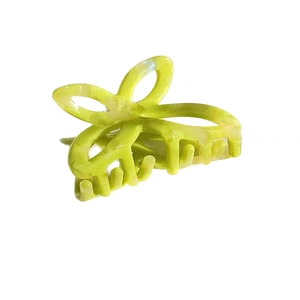 Elegant yellow-green acetate hair claw clip featuring a romantic hollow bow design