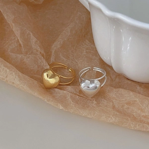 Close-up of gold and silver heart-shaped open rings with double-layer band design