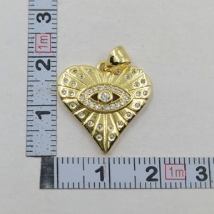 Detail of heart evil eye pendant with cubic zirconia and measurement ruler