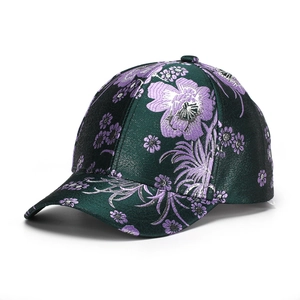 Detail of dark green floral embroidery on satin fabric of a vintage baseball cap