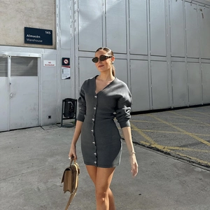 Détail d'une robe courte en tricot gris foncé avec des boutons métalliques en forme de cœur