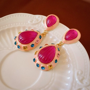 Vintage rose red water-drop crystal earrings with colorful rhinestones in a porcelain dish