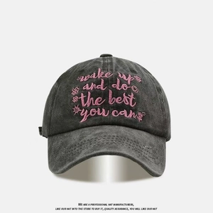 Washed black cotton baseball cap with pink embroidered wake up text and floral details