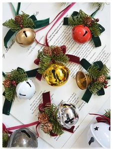 Close-up of Christmas bells with velvet ribbons and pine cones on vintage paper