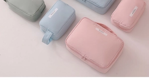 Waterproof nylon makeup bags in pink, light blue, and green with convenient handles