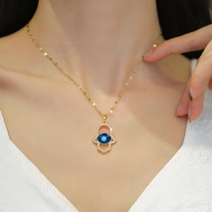 Titanium steel gold necklace with Hamsa Hand and blue Evil Eye pendant on a female model