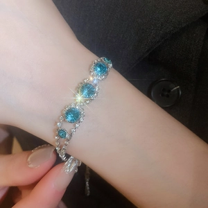 Close-up of sparkling silver bracelet with round blue stones and clear crystals on wrist