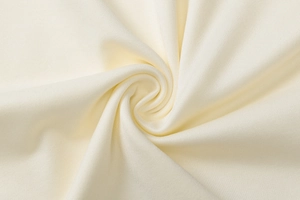 Macro detail of creamy white knitted fabric texture showing soft weave and elastic fibers