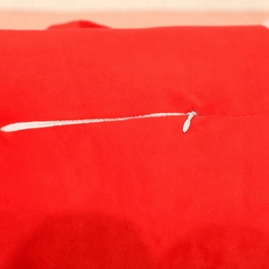 Detail of invisible zipper and soft red fabric on Santa Claus long plush pillow