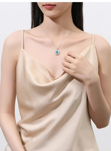 Close-up of elegant S925 silver necklace with blue gemstone pendant on a model