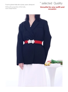 Red wide belt with silver floral buckle styled on a black blazer and white skirt